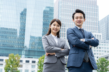 portrait of young asian business person standing in 
front of building