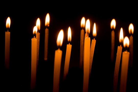 Group of burning candles in dark
