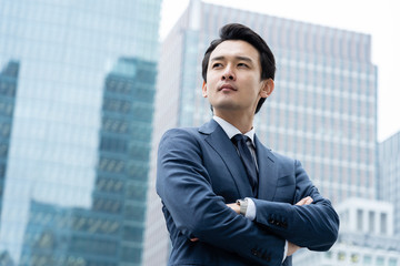 portrait of young asian business person standing in 
front of building