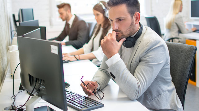 Pensive male it-support worker with eyeglasses in hand thinking about how to solve the problem