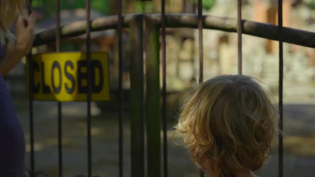 Slowmotion shot of a young woman and her little son visiting the Monkeys forest eco park in Ubud, Indonesia