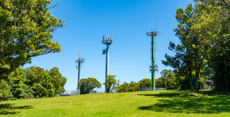 Telecommunication masts with TV antenna and mobile phone transmitter in beauty spot landscape with...