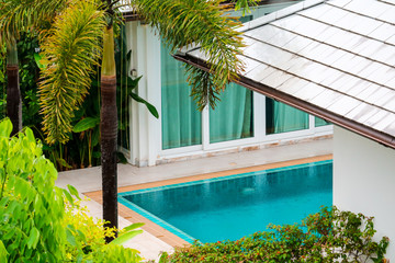 rain fall on swimming pool middle garden in villa