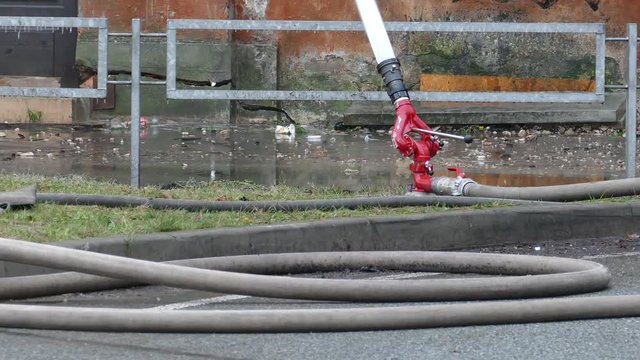 Close-up of firehose and water cannon on street during fire extinguishing event