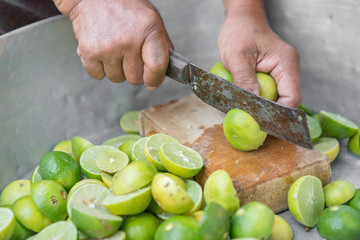 Man hand holding knife cutting lime