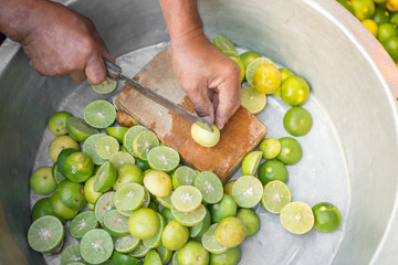 Man hand holding knife cutting lime