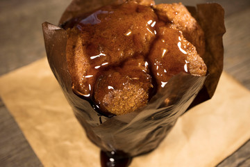 Chocolate muffin with cherry syrup on the morning table. Good morning with a sweet compliment.
