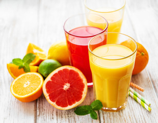 Glasses of juice and citrus fruits