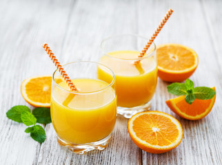 Glasses of juice and orange fruits