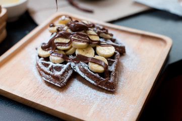 homemade Chocolate waffles with bananas sprinkled and sugar.