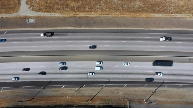 Cars and trucks sharing the road on an open highway.