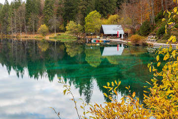Fototapeta premium Autumn sunrise on the lower lake of Fusine. Explosion of colors