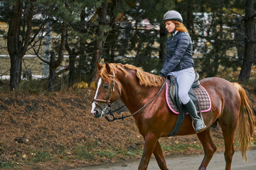 Young woman jockey in white black dress and black boots, takes part in equestrian competitions.