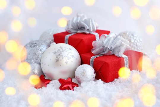 Christmas decorative balls and gifts on snow. Festive New Year background