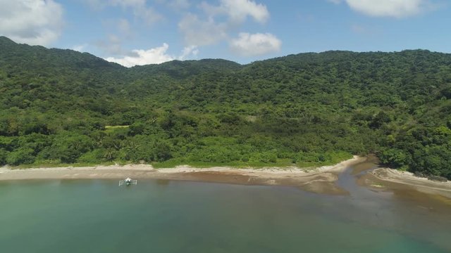 Aerial view of tropical beach in bay with turquoise water. Siwangag Cove. Coast of tropical island Palau with mountains covered rainforest. Santa Ana, province of Cagayan, Philippines.