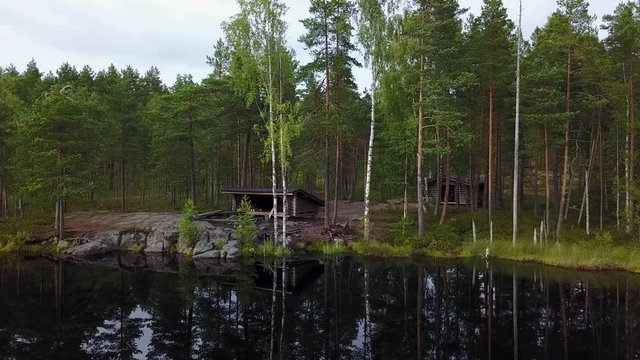 A lean-to surrounded by forest and a calm lake at Isoj&auml;rvi national park in Finland