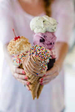 Girl Holding out Three Ice Cream Cones