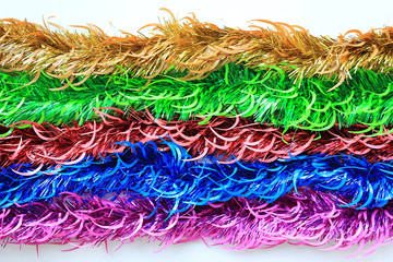 Multi colors bunch fur or Christmas tree tinsel garland on white background. Christmas and New year celebration.