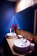 bathroom interior with two wooden sinks and blue walls in a modern style