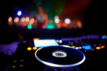Fototapeta na wymiar club DJ in headphones with sound mixer in nightclub