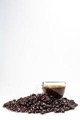 Naklejka premium The glass mug of coffee and coffee bean