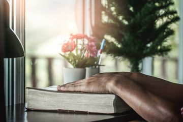 Close up Holy Bible with hands of man praying, christian concept.