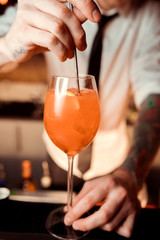 An orange cocktail is on the table in a cafe / restaurant. Bar. Orange cocktail on the table a cozy cafe, with a copy space for text. Alcoholic drink based on a table with ice and oranges.