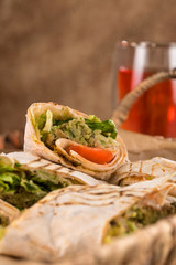Pieces of vegetarian falafel roll on a wicker tray. Serving dishes.. Traditional Middle Eastern snack. Fastfood.