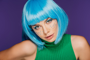 attractive glamor girl with blue wig and stars on face, isolated on purple