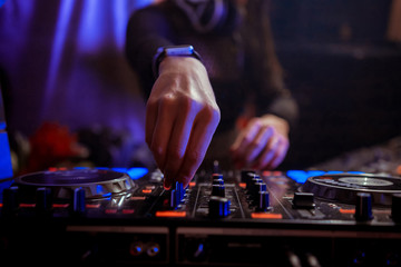 Dj mixes the track in the nightclub at party
