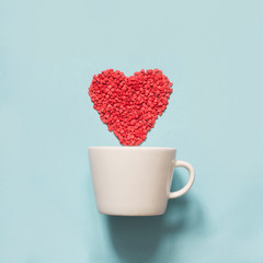 Valentine's card. Creative heart of red confetti in cup. View from above. Flat lay.