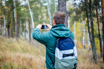 hiker is taking a photo with his smartphone