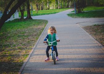 cute little girl riding runbike in park, active kids