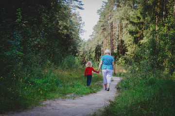 senior grandmother with little granddaughter walk in nature