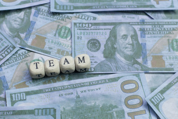 Fototapeta premium Team word on wood brick background banknote..