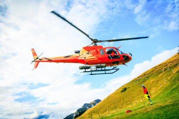 Fototapeta na wymiar Red Helicopter In The Swiss Alps