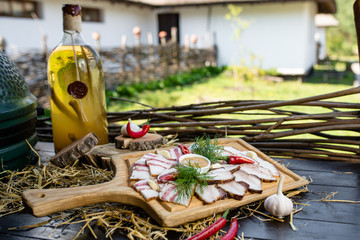 Ukrainian bacon on a wooden board with sauce and dill