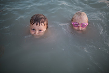 boy and girl swim in water