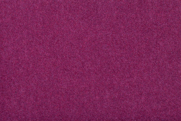 Dark purple matt suede fabric closeup. Velvet texture of felt.