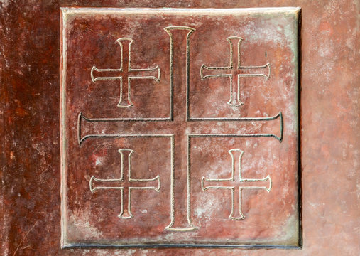 Close up texture of ancient metallic plate with cross sign