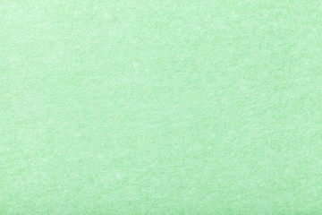 Light green matt suede fabric closeup. Velvet texture of felt.