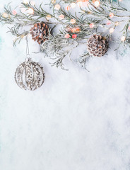 Christmas background  with vintage bauble , frozen branches and cones on snow with bokeh, top view...