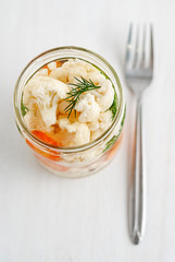 Jar with pickled cauliflower near fork