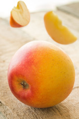 Delicious red apple with flying slyces around