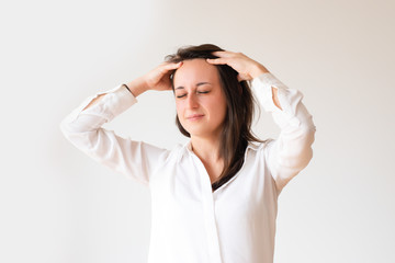 Tired female student touching painful temples. Portrait of young manager with closed eyes having headache. Isolated on white. Headache concept