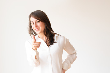 Young manager in white blouse pointing at you. Smiling young woman pointing at camera with finger. Isolated on white. Advertisement concept