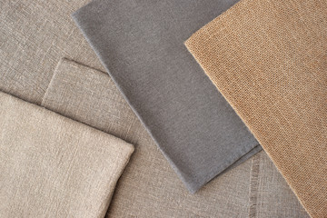 Coarse fabric creates for design. Textured background in the form of burlap and coarse cotton. Design items and clothes from coarse fabric. Sewing, style and fashion.