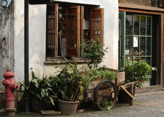 Decorated entrance showing a traditional pushcart with plants infront a shop and cafe in the old quarter in Suzhou city, China, Asia
