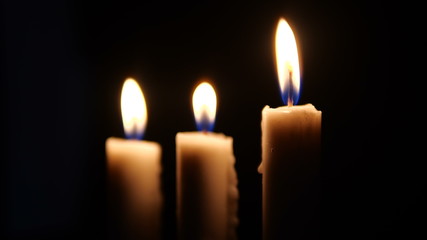 Fototapeta na wymiar Footage of closeup of candle on black background. Christmas