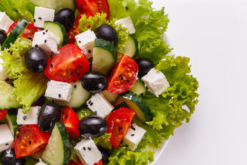 Greek salad on a white acrylic background